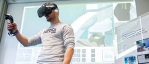 Mann mit VR-Brille, der vor einer Wand steht, auf die Informationen über Virtual Reality reproduziert wird