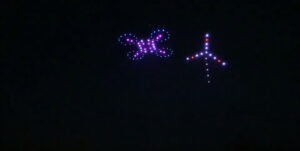 Auf dem Nachthimmel wurden mit Drohnen eine Windmühle und ein Schmetterling in lila Farben konstruiert